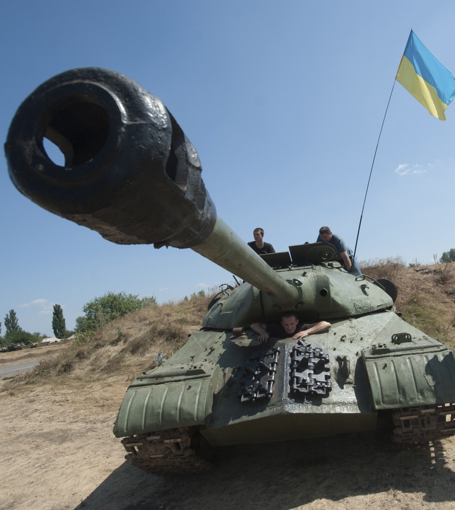 Ukrainian government soldiers drive their tank with a Ukrainian national flag in Donetsk region, eastern Ukraine, Saturday.
