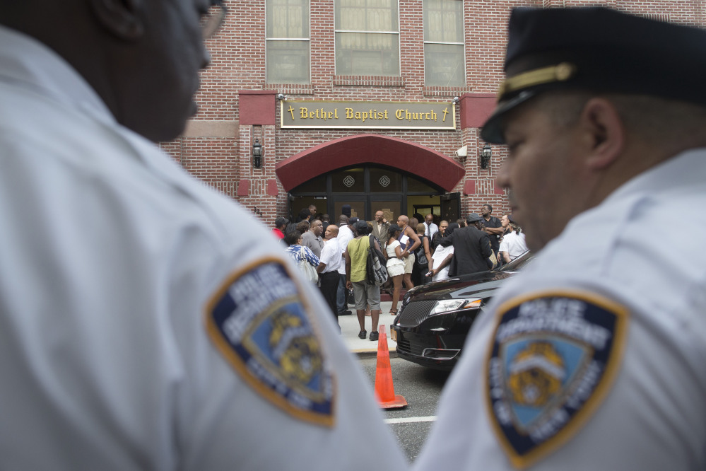 New York City police officers stand at their post as mourners arrive for the funeral service of Eric Garner at Bethel Baptist Church in Brooklyn last month.