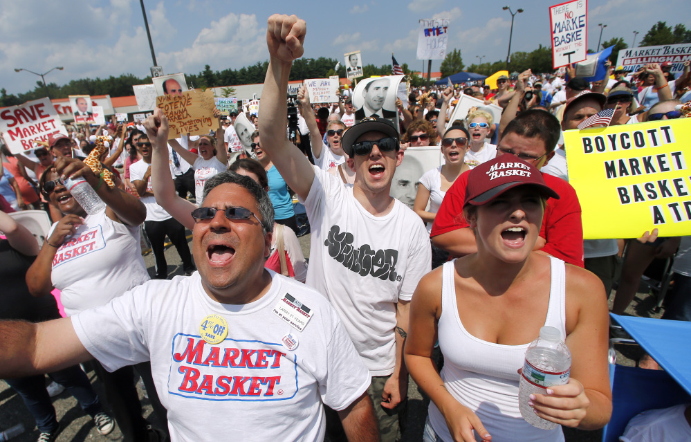 Market Basket employees from the Billerica, Mass., store cheer during a rally at Market Basket in Tewksbury, Mass., last week. Thousands of Market Basket supermarket employees and their supporters are calling for the reinstatement of their fired CEO.
