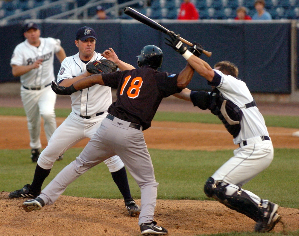 Bluefish catcher John Nathans, right, tries to stop Long Island Ducks’ Jose Offerman from hitting pitcher Matt Beech with a bat during a 2007 Atlantic League game in Bridgeport, Conn. “I’m known for going out and protecting my pitcher,” Nathans said. “I’d rather be known as that guy than the guy who didn’t go out, the guy who sat at home plate and watched his pitcher get beat.”
