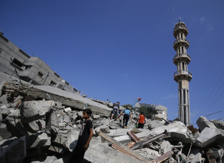 Palestinians stand in rubble of the al-Qassam mosque in Nuseirat refugee camp, central Gaza Strip, after it was hit by an Israeli airstrike, Saturday.