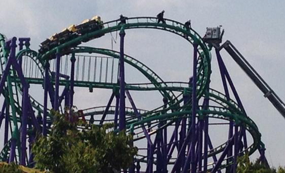 Firefighters reach riders stranded on The Joker’s Jinx roller coaster at Six Flags America in Upper Marlboro, Maryland on Sunday.