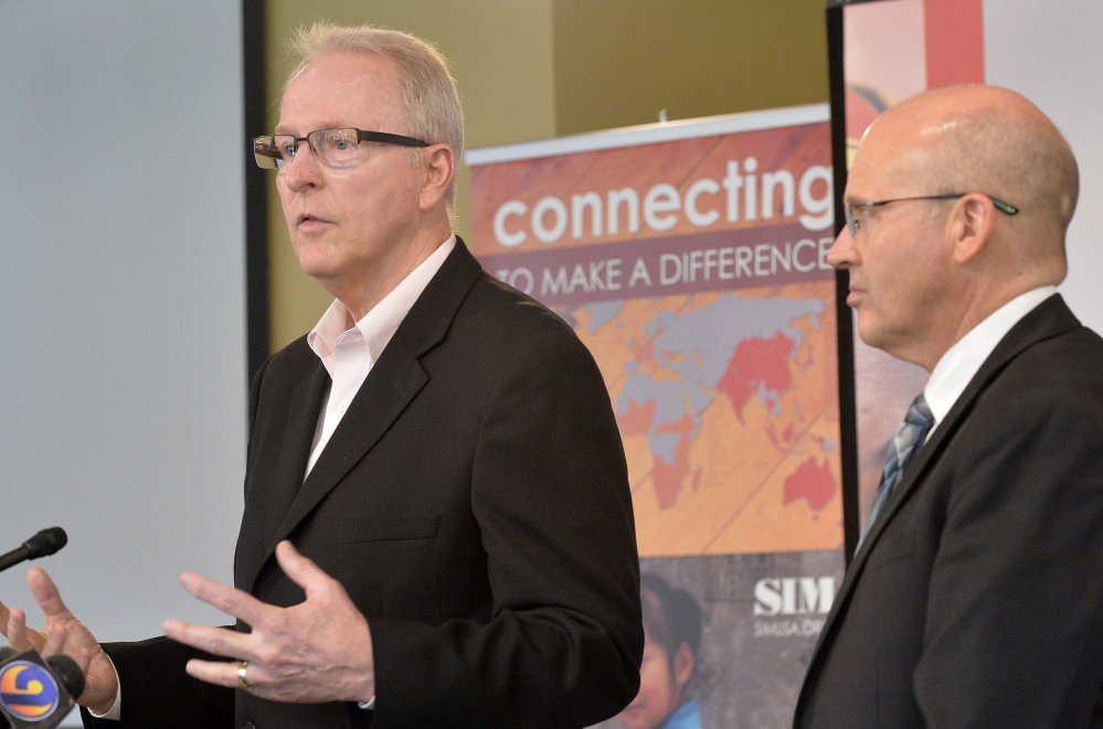 SIM USA President Bruce Johnson, left, and Dr. Stephen Keener, director of the Mecklenburg County Health Department, speak during a news conference Monday at SIM USA headquarters in Charlotte, N.C.