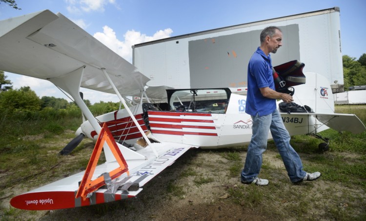 Billy Werth removes belongings from his single-engine experimental aircraft Monday at Copp Motors in Cumberland, where the wreckage was towed after he crash-landed Sunday in Standish. “I’m just happy to be here,” said Werth, whose injuries were minor.