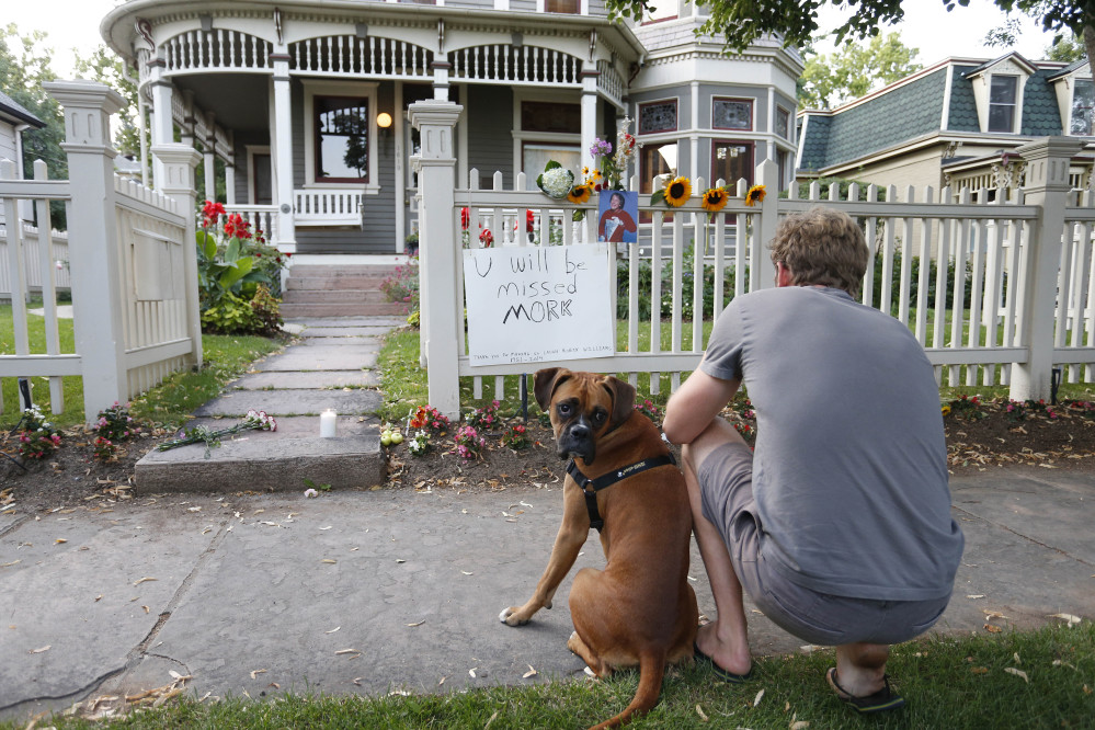 Caine Delacey, of Australia, with his dog Dia, takes a picture at the home where the 80s TV series Mork & Mindy, starring the late Robin Williams, was set, in Boulder, Colo., Monday.