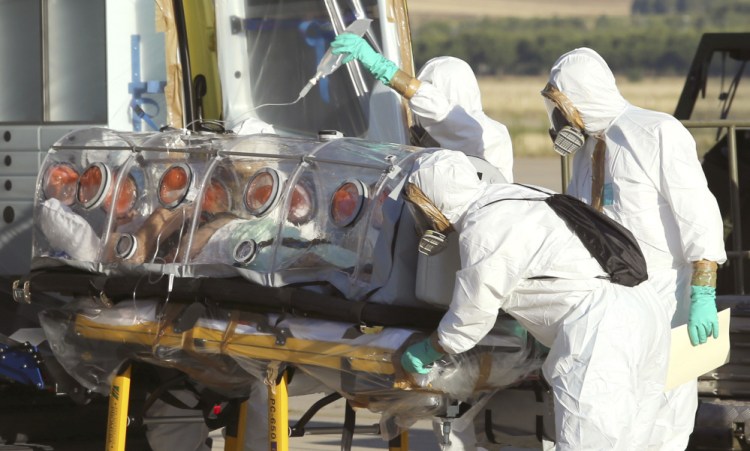 Aid workers and doctors transfer Miguel Pajares, a Spanish priest who was infected with the Ebola virus while working in Liberia, from a plane to an ambulance as he leaves the Torrejon de Ardoz military airbase, near Madrid, Spain.