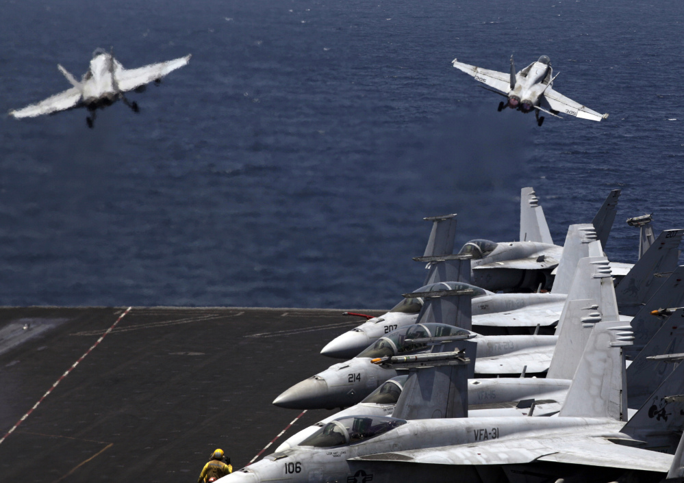 U.S. F/A-18 fighter jets take off for a mission in Iraq from the flight deck of the U.S. Navy aircraft carrier USS George H.W. Bush, in the Persian Gulf on Monday.