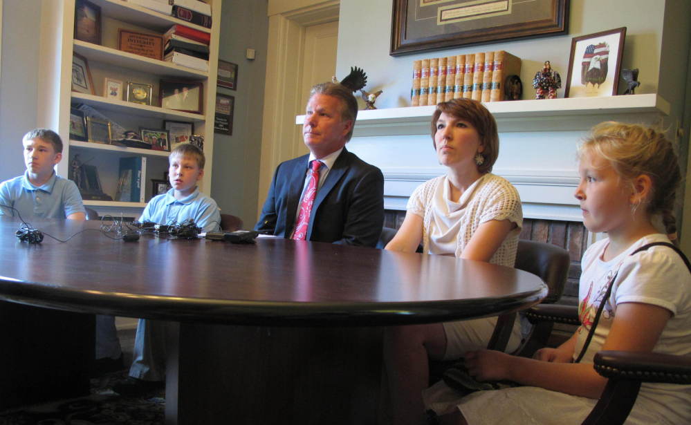 The wife and children of Jeffrey Fowle sit with their attorney, Tim Tepe, center, during a news conference Tuesday.