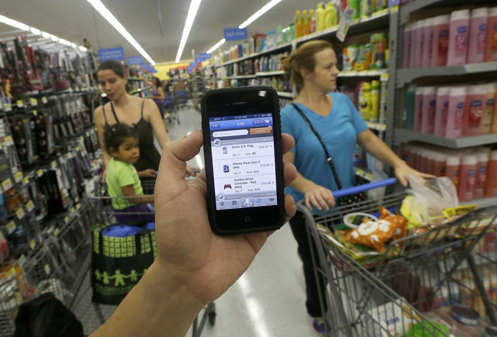 A Wal-Mart representative demonstrates the now-discontinued Scan & Go mobile application last September at a Wal-Mart in San Jose, Calif. Instead of looking at the app as a failure, Wal-Mart took what it learned from Scan & Go to create another service: It found that customers like being able to track their spending before checking out.