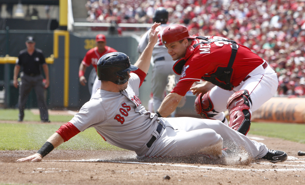 Boston Red Sox’ Daniel Nava, left, scores in front of Cincinnati Reds catcher Devin Mesoraco, right, after a Mike Napoli ground ball in the first inning of a baseball game, Wednesday, in Cincinnati.