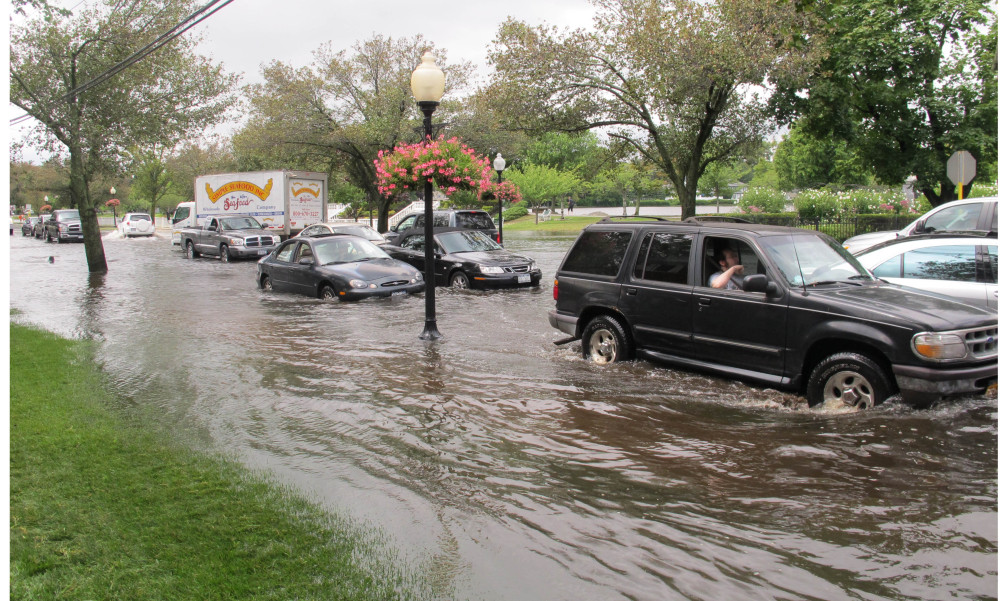 Vehicles attempt to maneuver down a flooded Montauk Highway in Babylon,  N.Y., Wednesday. The Associated Press