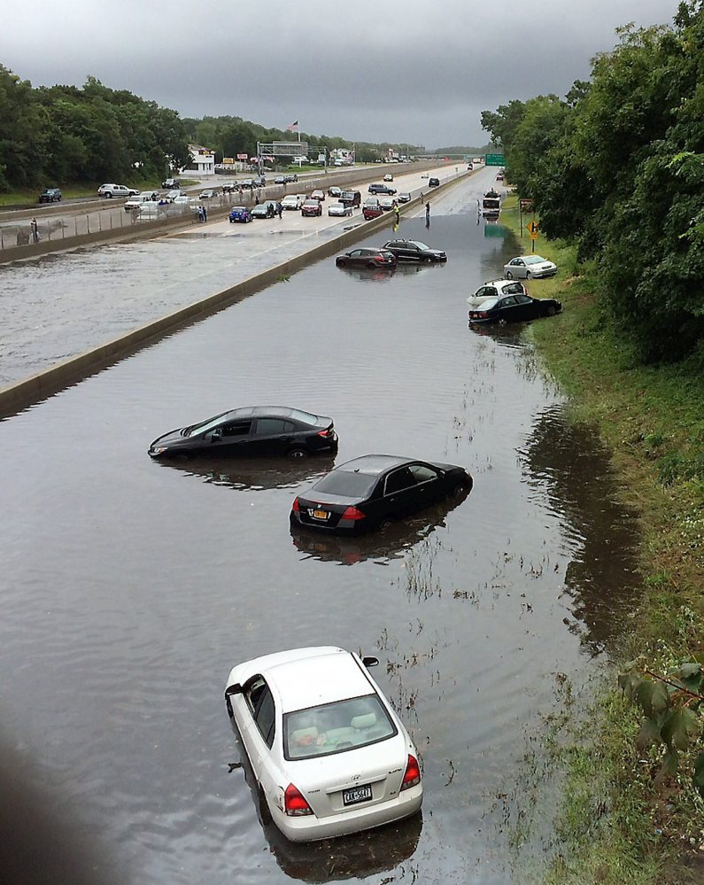 Vehicles are submerged Wednesday on a flooded section of Sunrise Highway in East Islip on New York’s Long Island, where an entire summer’s worth of rain fell in a matter of hours. One death was reported, in a weather-related crash on the Long Island Expressway.