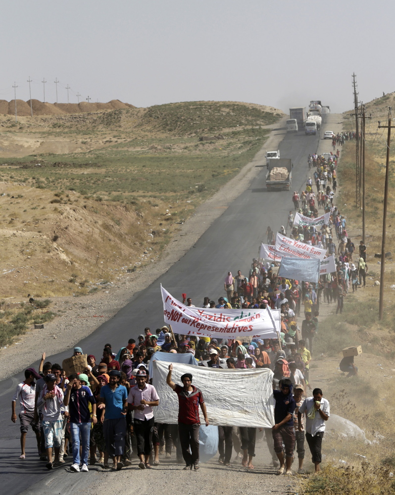 Displaced people of the minority Yazidi sect, who fled the violence in the Iraqi town of Sinjar, take part in a demonstration Wednesday at the Iraqi-Syrian border crossing in Fishkhabour, Dohuk province, Iraq.