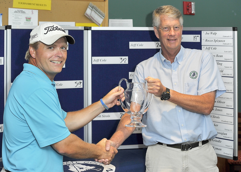 Ricky Jones, left, accepts the trophy from Randy Hodsdon, director of rules and competition, for his 6-and-4 defeat of Jeff Coles to win the Maine Match Play Golf Tournament played at Sable Oaks Golf Course.