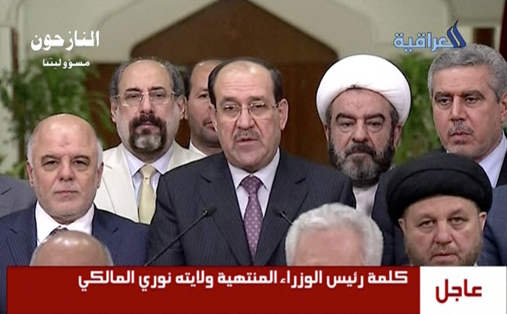 In this image taken from video Thursday, Nouri al-Maliki, Iraq’s prime minister for the past eight years, relinquishes his post to fellow Dawa Party member Haider al-Abadi.