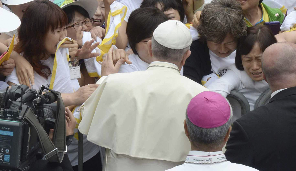 Pope Francis consoles family members of the victims of the sunken ferry Sewol upon his arrival for the Mass of Assumption of Mary at Daejeon World Cup stadium in Daejeon, south of Seoul, South Korea, Friday, Aug. 15, 2014. In his final prayer, Francis reached out to the survivors and families with words of comfort: “May the Lord welcome the dead into his peace, console those who mourn and continue to sustain those who so generously came to the aid of their brothers and sisters,” he said.