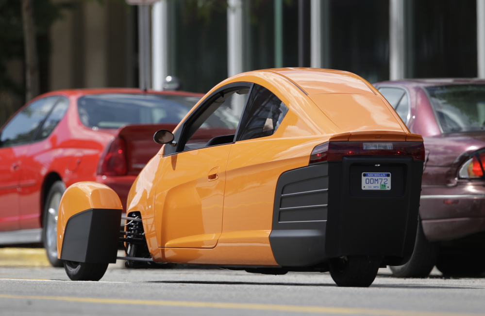 The Elio, a three-wheeled prototype vehicle, is shown in traffic in Royal Oak, Mich.