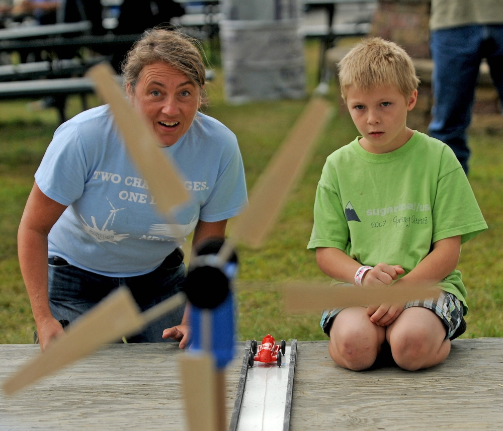 Tanner Mayo, 9, of Temple learns about wind power Friday from Lisa Twombly with the build-your-own-wind-blade challenge at the Skowhegan State Fair