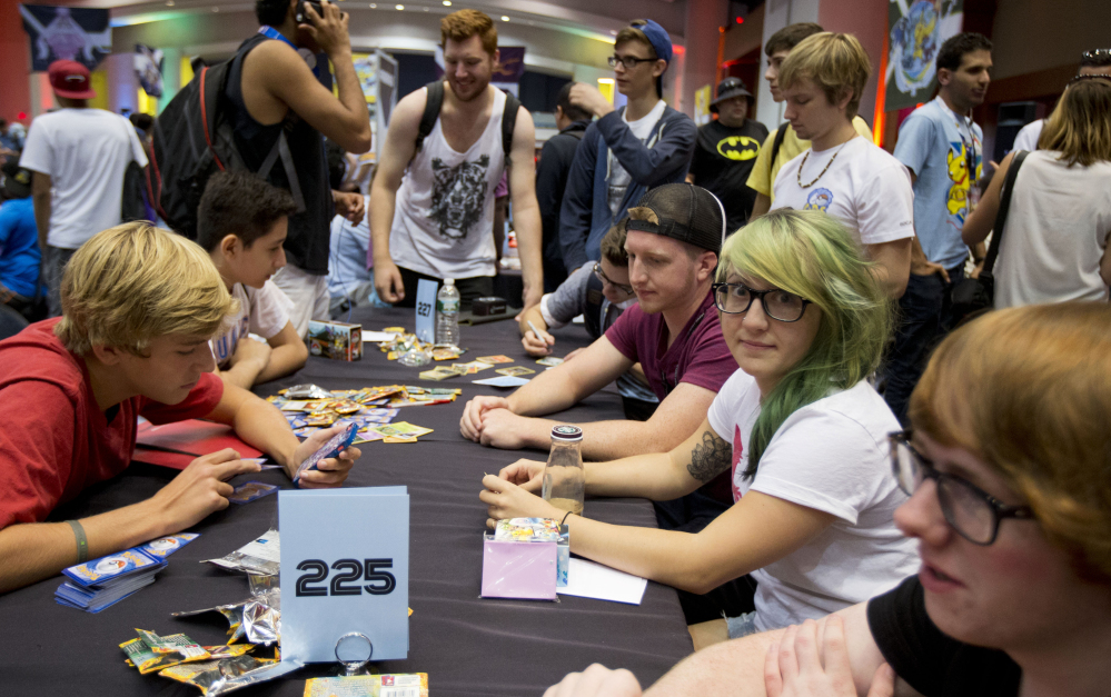 Competitors, from left, Henry Ross-Clunis, Kyle Sabelhaus, Nicholena Moon, and Jimmy Pendarvis, trade cards and discuss strategy for the last chance qualifier in the Pokemon trading card game for the 2014 Pokemon World Championships in Washington on Friday.