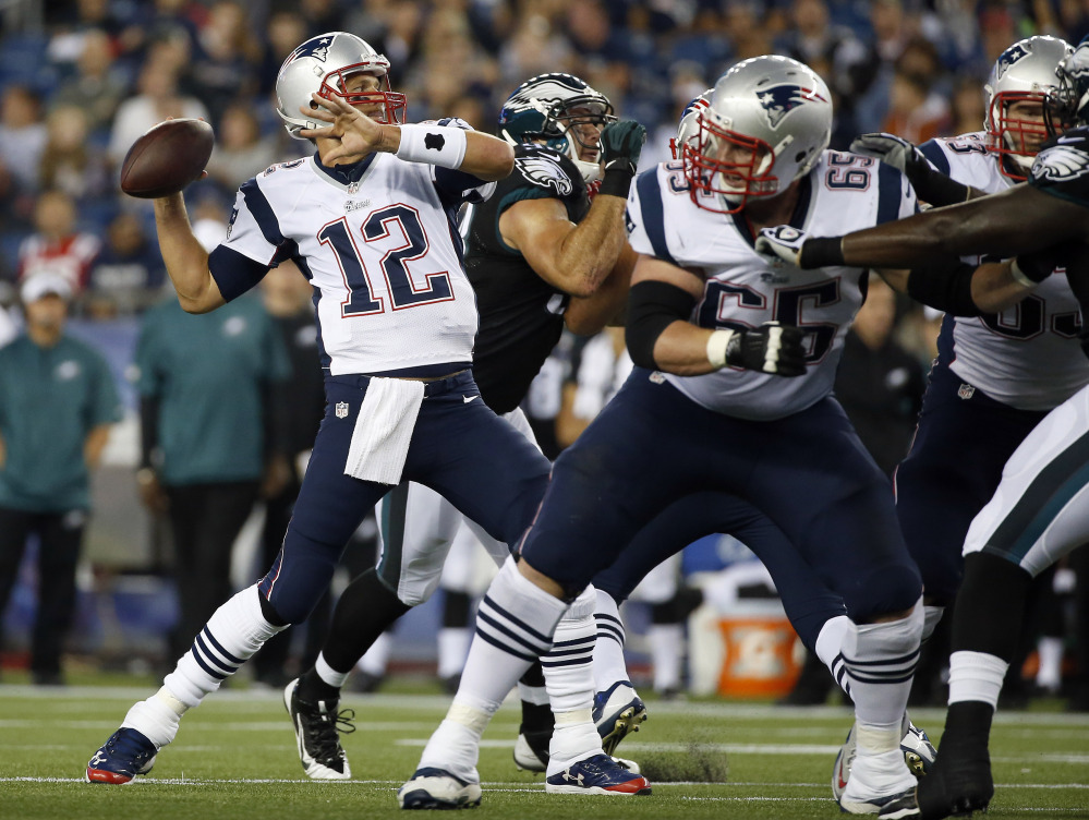 New England Patriots quarterback Tom Brady passes against the Philadelphia Eagles behind a block by tackle Jordan Devey (65) in the first quarter Friday night in Foxborough.