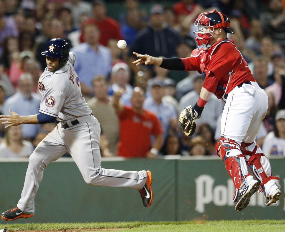 Gregorio Petit of the Astros avoids Red Sox catcher Christian Vazquez, whose throw to pitcher Burke Badenhop at the plate wasn’t in time to prevent Petit from scoring the tying run in the eighth inning Friday night.