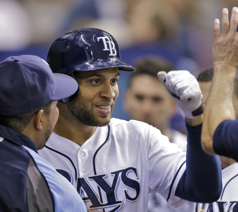Tampa Bay Rays’ James Loney high-fives teammates after hitting a home run off New York Yankees relief pitcher Esmil Rogers during Friday’s victory.
