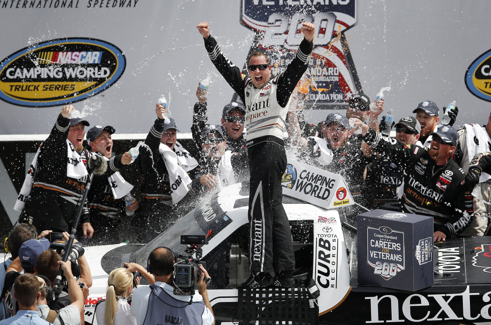 Driver Johnny Sauter, center, celebrates in Victory Lane after winning the NASCAR Camping World truck series auto race at Michigan International Speedway in Brooklyn, Mich., on Saturday