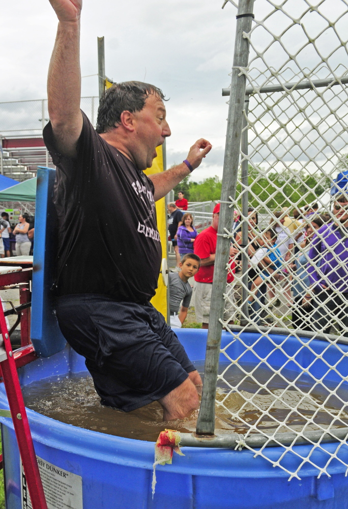 Dave Hopkins hits the dunk tank water when somebody hit the button with a football during a fundraiser on Saturday at Cony High’s Alumni Field. Alison Lucas, mother of former Cony quarterback Ben Lucas, was recently diagnosed with cancer.
