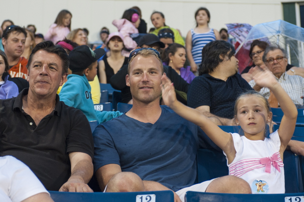 From left, Tom Sheehan, Barry Hertzler and his daughter, Emersyn Hertzler, watch a Sea Dogs game. Sheehan was the host family for Hertzler for three seasons.