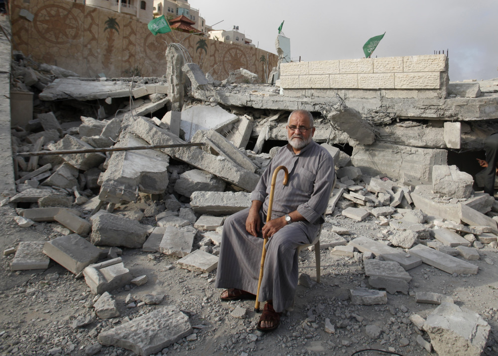 A Palestinian sits in the rubble of the house of Hussam Qawasmeh, one of three Palestinians identified by Israel as suspects in the killing of three Israeli teenagers, after it was demolished by the Israeli army in the West Bank city of Hebron on Monday.