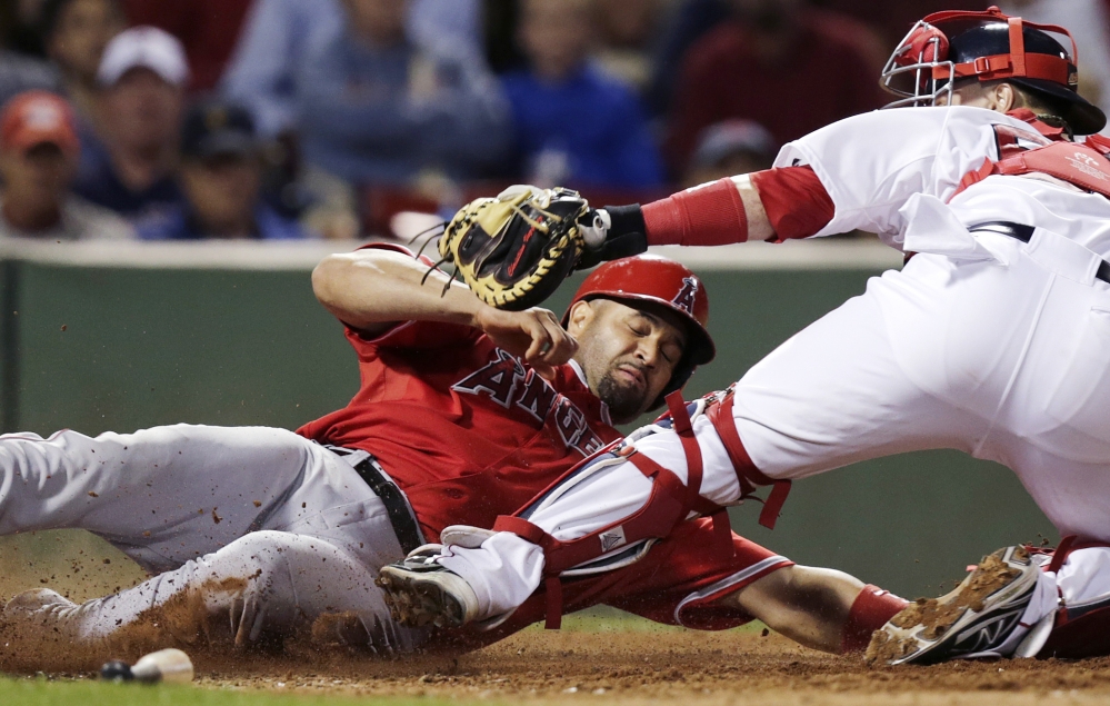 Los Angeles Angels' Albert Pujols is tagged out at home by Red Sox catcher Christian Vazquez during the eighth inning at Fenway Park in Boston on Monday. Pujols was originally called safe, but the call was overturned by video replay review.
The Associated Press