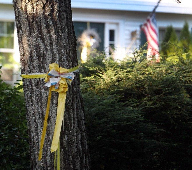A ribbon is tied to a tree outside the home of American freelance journalist James Foley on Tuesday in Rochester, N.H. Islamic State militants released a video Tuesday that purports to show the killing of Foley.