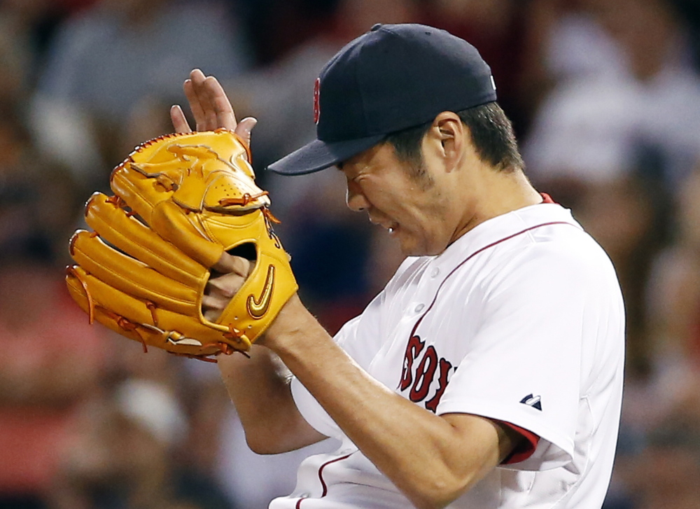 Red Sox relief pitcher Koji Uehara grimaces as he gives up a tie-breaking RBI double to the Los Angeles Angels’ Chris Iannetta in the ninth inning Tuesday night at Fenway Park.