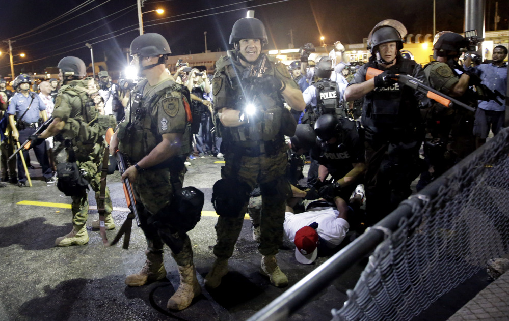 A man is arrested as police try to disperse a crowd during protests in Ferguson, Mo. On Saturday, Aug. 9, a white police officer fatally shot Michael Brown, an unarmed black 18-year old, in the St. Louis suburb.