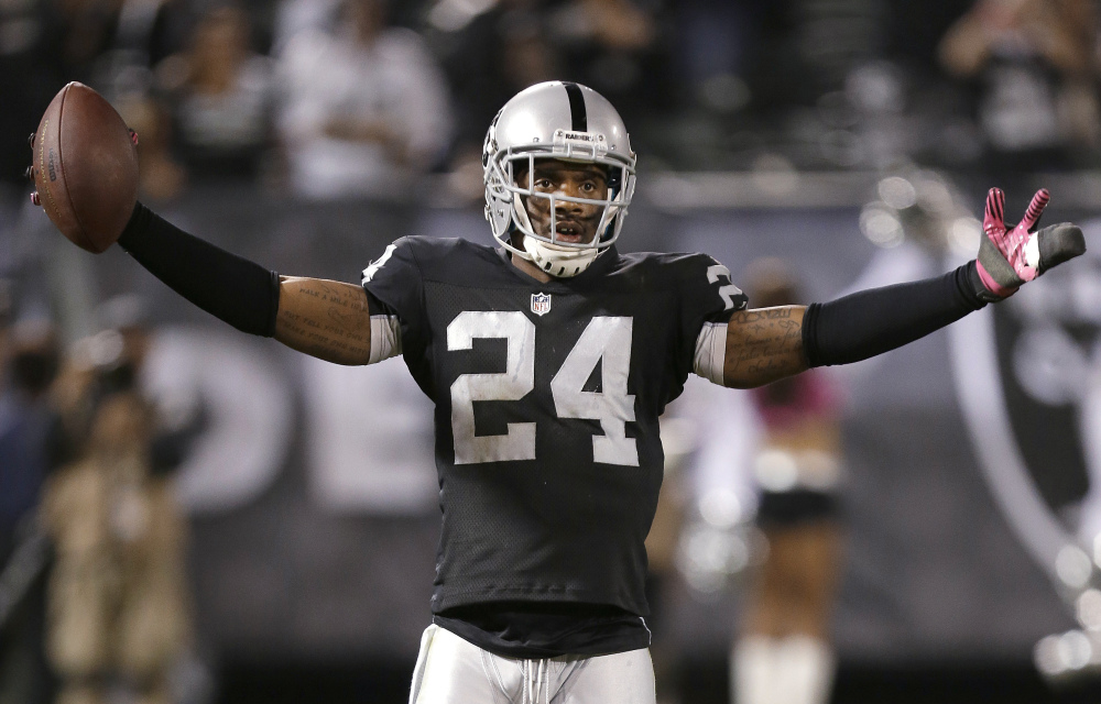 In this Oct. 6, 2013, file photo, Oakland Raiders cornerback Charles Woodson celebrates after intercepting San Diego Chargers quarterback Philip Rivers during an NFL football game in Oakland, Calif.