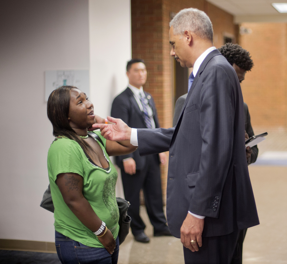 Attorney General Eric Holder talks with Charnell Hurn, 20, a student at St. Louis Community College Florissant Valley, Wednesday in Ferguson, Mo.