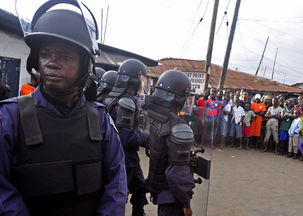 Liberian security forces control a crowd Wednesday in Monrovia’s West Point slum as the government clamps down on the movement of people to stop the spread of Ebola.