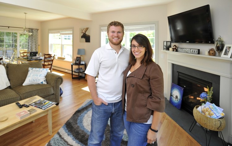 Rob and Samantha McNamee pose in the home they built in Sebago Heights Estates in Windham. “Our money goes a lot farther in Maine than in Massachusetts,” Rob McNamee says.