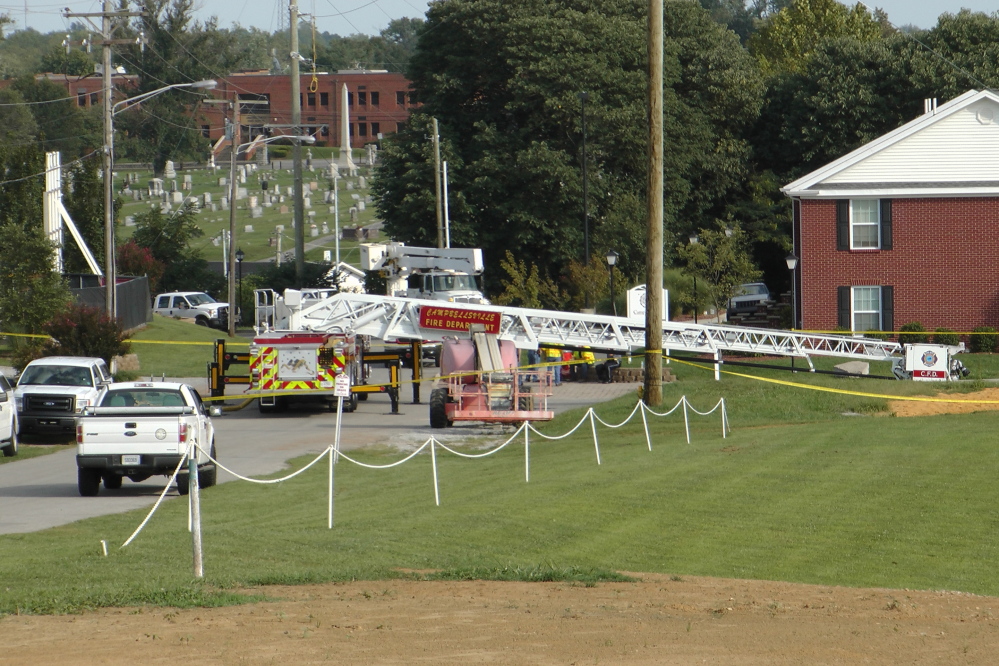 A Campbellsville Fire Department truck with the ladder extended remains at the scene where four firefighters were injured after an ice bucket challenge during a fundraiser for ALS on Thursday in Campbellsville, Ky. Officials say the ladder got too close to a power line and electricity traveled to the ladder. The Associated Press