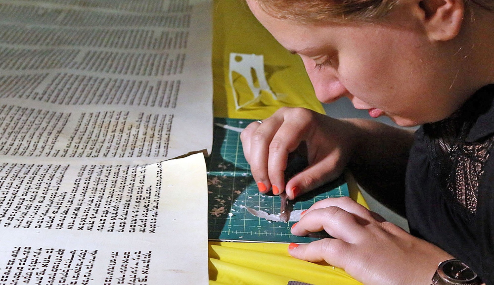 Rachel Salston of Los Angeles, who is a “soferet,” one of the country’s few female scribes, repairs a damaged Torah used by the Jewish Academy of Orlando in Maitland, Fla.