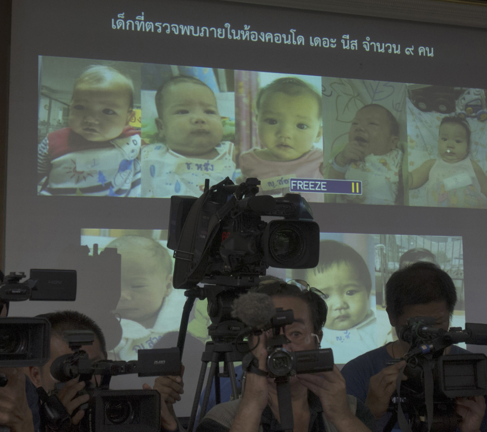 Pictures of babies fathered by a Japanese man who is at the center of a surrogacy scandal are displayed at police headquarters in Chonburi, Thailand.