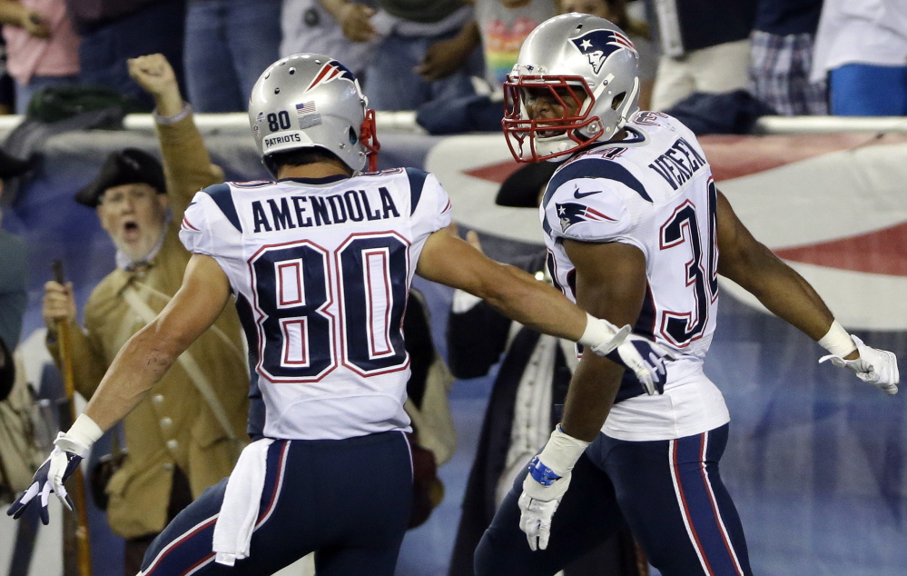 Shane Vereen, right, celebrates with Danny Amendola after catching one of his two touchdown passes Friday night from Tom Brady during the 30-7 victory against Carolina. Vereen, who has had injury woes, is in contention to become the Pats’ primary running back.