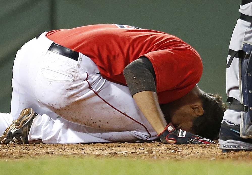 Boston’s Xander Bogaerts lies on the ground after being hit in the head by a pitch in the fifth inning of a 5-3 loss to the Mariners at Boston on Friday. Bogaerts briefly stayed in the game, then left for an evaluation.