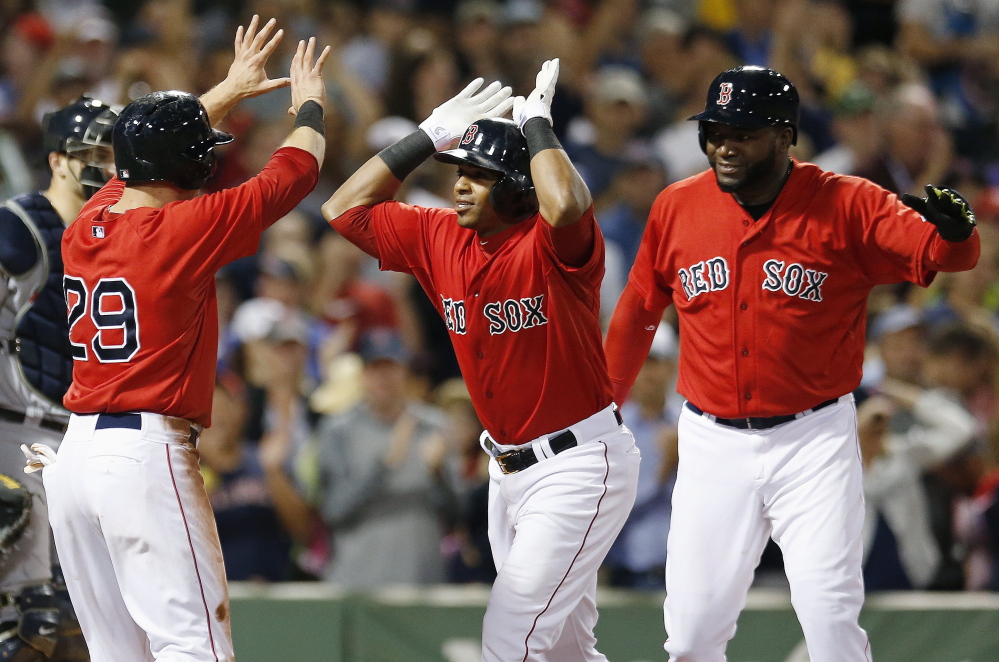 Red Sox outfielder Yoenis Cespedes, center, celebrates his home run, which also drove in Daniel Nava (29) and David Ortiz, right, in the sixth inning against the Seattle Mariners in Boston on Friday.