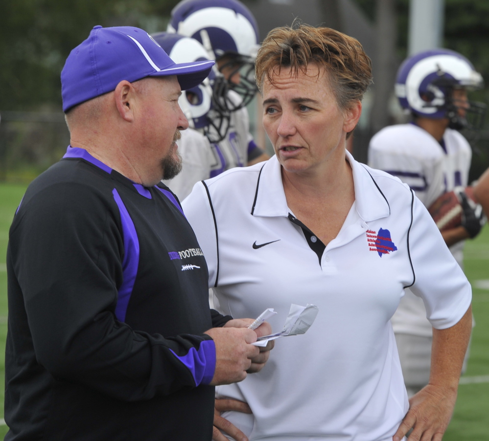 Mel Craig, right, the Deering High athletic director talking with football coach Matt Riddell, said parents often become involved in their child’s sports when a problem arises, and it’s best to meet parents in person to resolve conflicts.