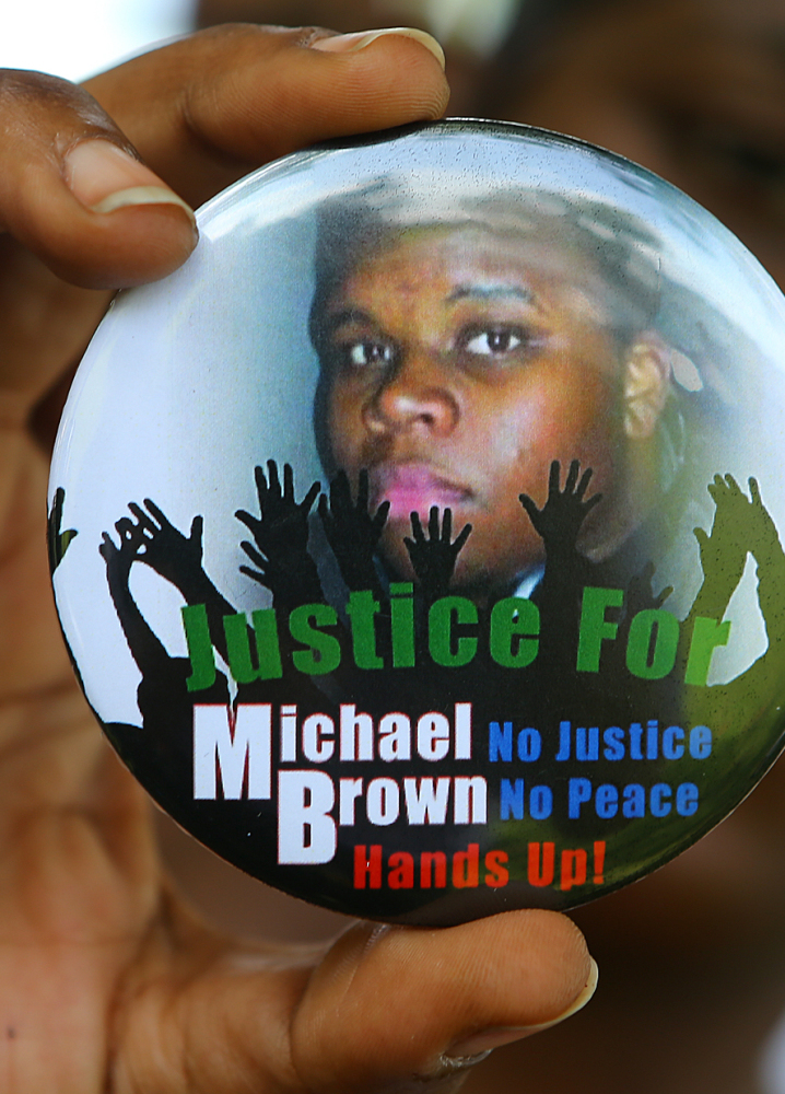 Michael Brown Jr., who was fatally shot by a police officer in Ferguson, Mo., is shown in a photo on a button.