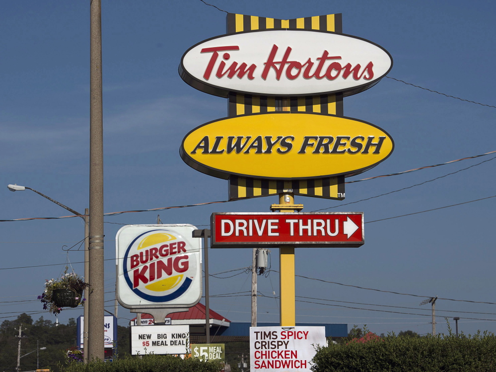 Burger King and Tim Hortons signs stand in Lower Sackville, Nova Scotia. Burger King is in talks to buy Tim Hortons, in hopes of creating a new company headquartered in Canada.