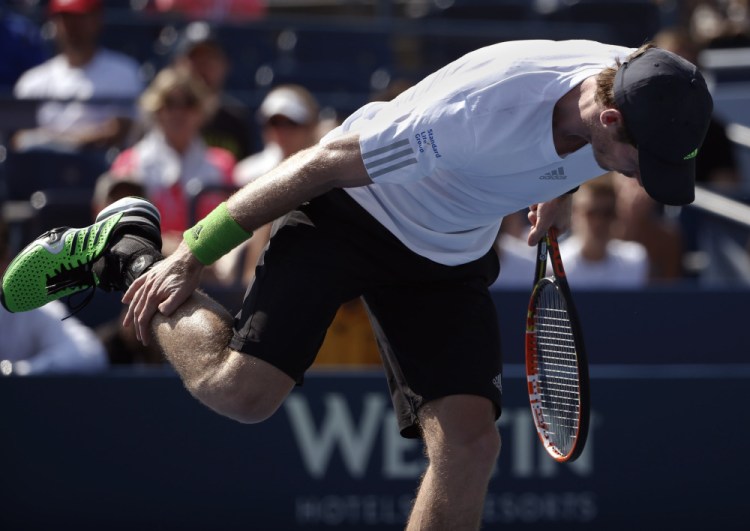 Andy Murray of the United Kingdom stretches his leg between serves against Robin Haase of the Netherlands during the opening round of the 2014 U.S. Open tennis tournament, Monday.