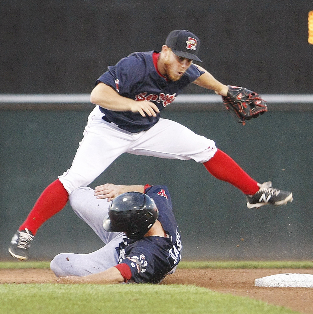 Sean Coyle leaps over Reading’s Brock Stassi after making an out at second base and attempting the throw to first base in the second inning Monday night at Hadlock Field.