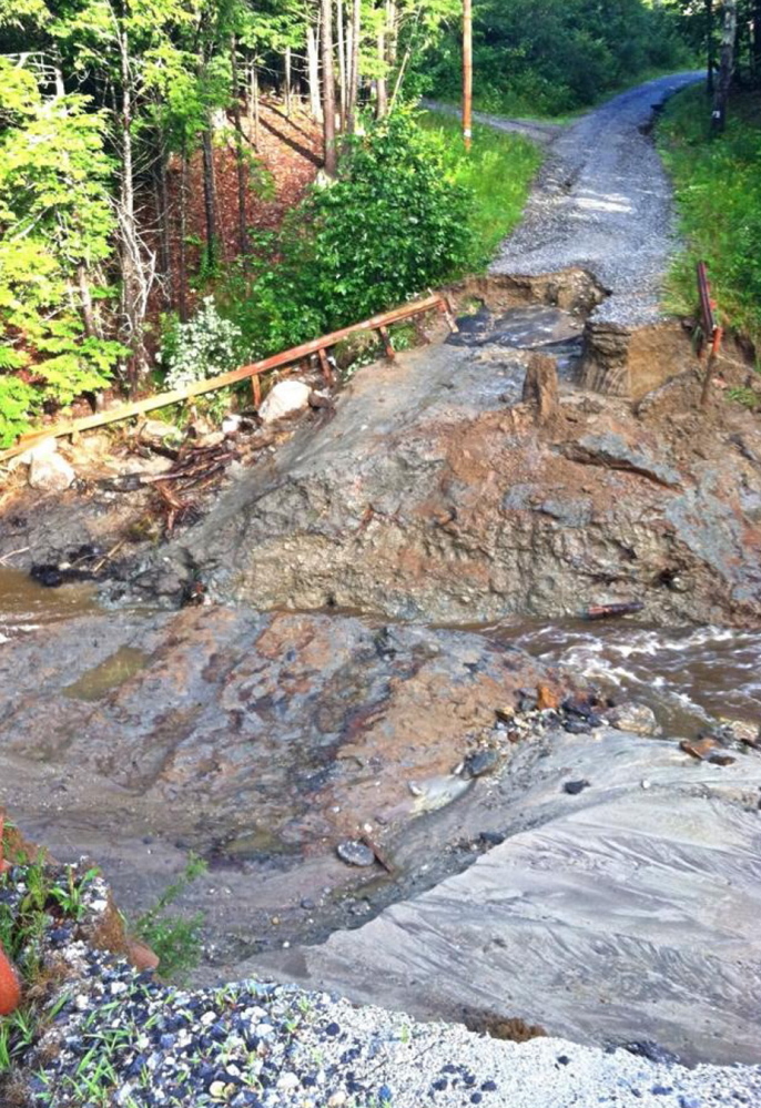 An overflowing stream caused by a record rainfall damaged this access road to two properties in Freeport. The photo was taken before temporary repairs were made.